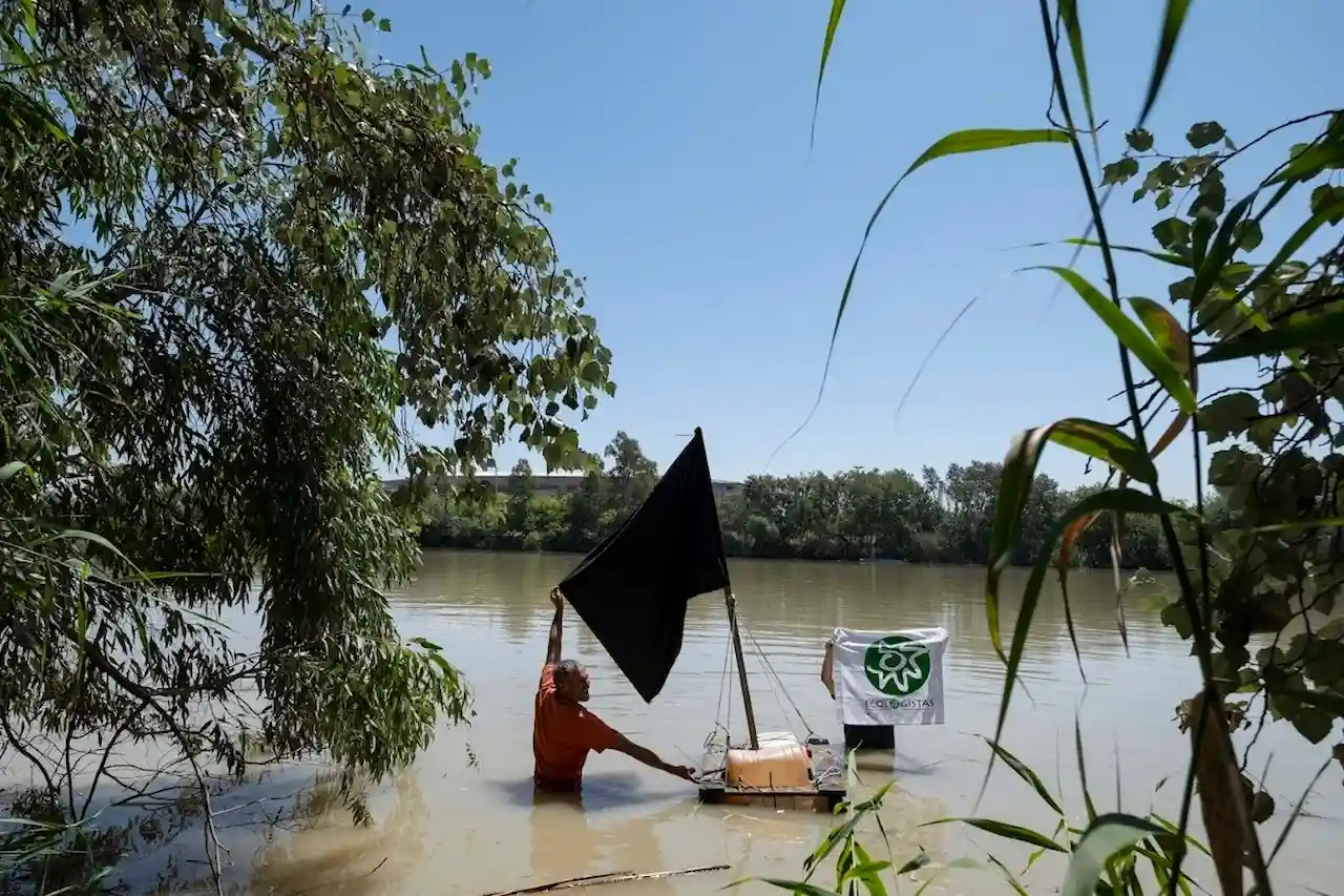 Bandera negra en el Guadalquivir en el punto de vertido contaminante "previsto" por una mina de Aznalcóllar / Foto: Ecologistas en Acción Bandera negra en el Guadalquivir en el punto de vertido contaminante "previsto" por una mina de Aznalcóllar / Foto: Ecologistas en Acción