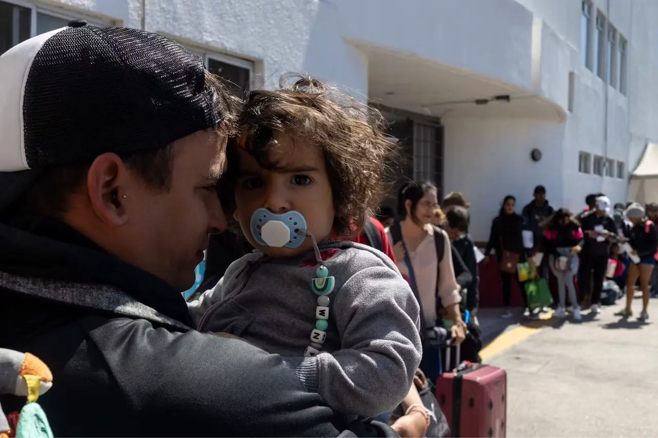 Familia migrante junto a un centro de acogida / Foto: The Conversation
