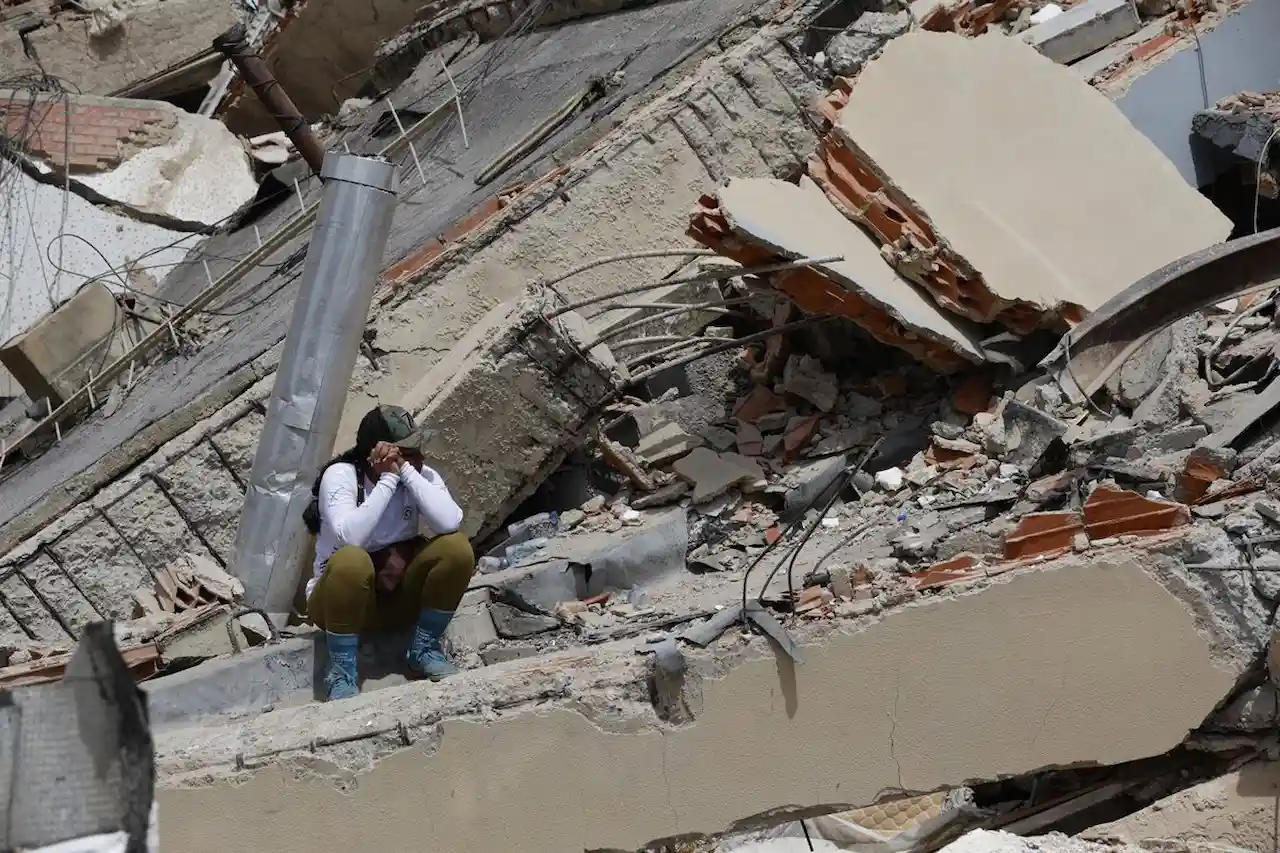 Una mujer permanece sentada entre los escombros tras el derrumbe de un edificio en Caraballeda, en La Guaira, Venezuela / Foto: EP