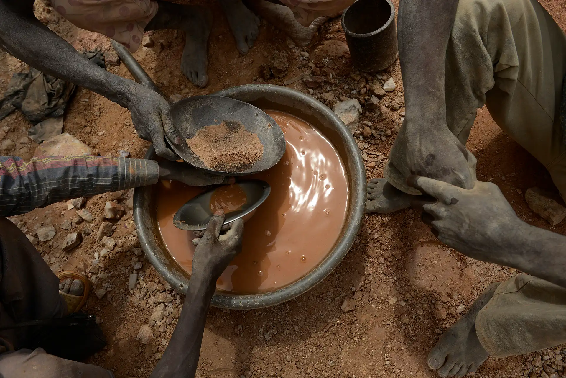 Minas de Zemse, Yalgo, Burkina Faso. Varios mineros criban la tierra con agua en una batea colectiva. El proceso es lento, el resultado incierto / Foto: Alfons Rodríguez