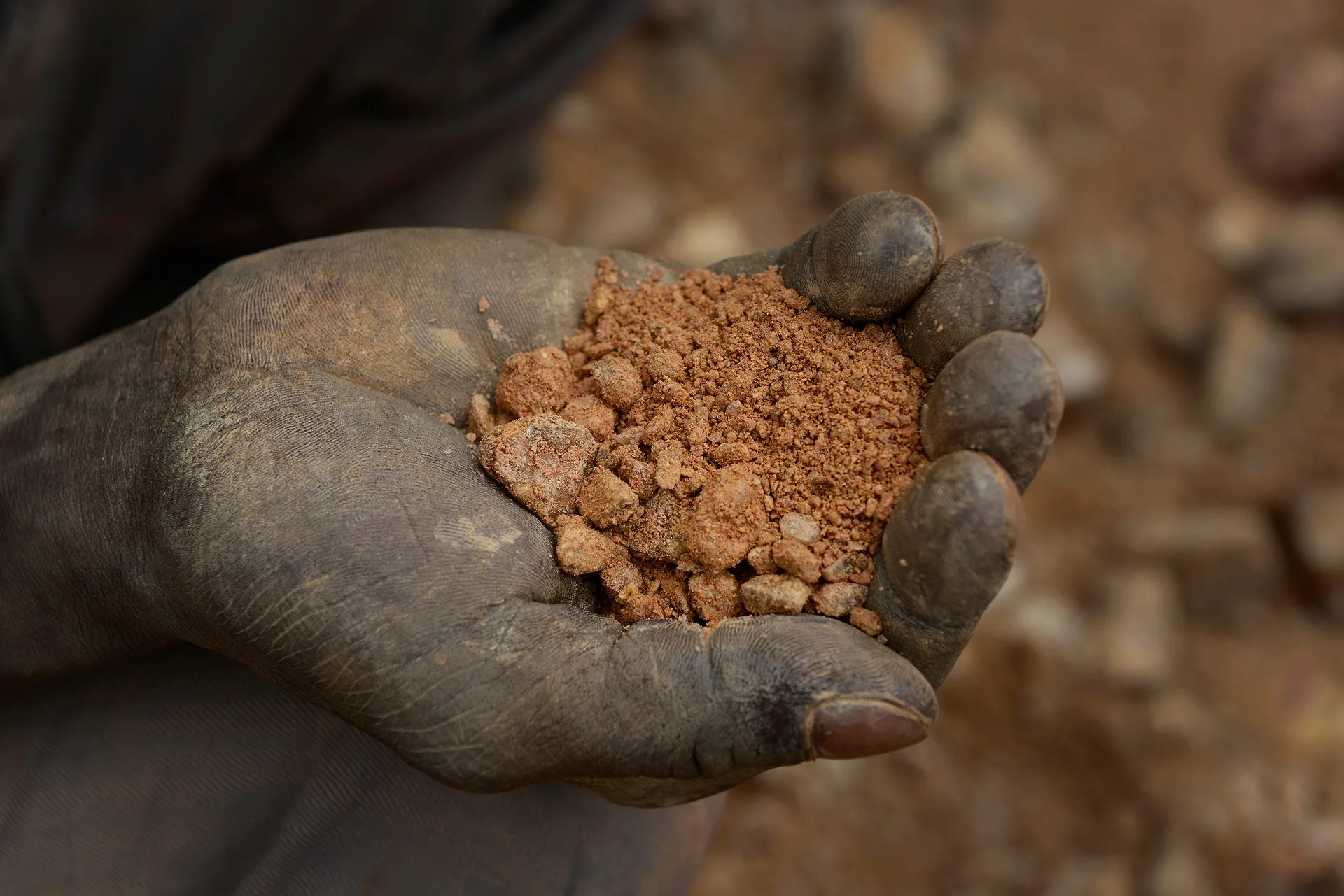 Minas de Zemse, Yalgo, Burkina Faso. Una mano sostiene la tierra extraída. En este polvo rojo buscarán, durante horas, partículas de oro invisibles / Foto: Alfons Rodríguez
