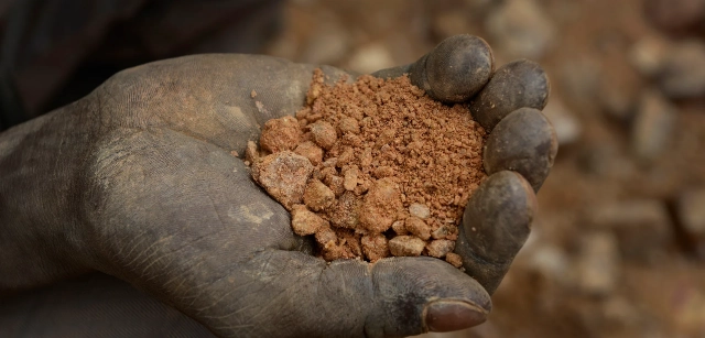 Minas de Zemse, Yalgo, Burkina Faso. Una mano sostiene la tierra extraída. En este polvo rojo buscarán, durante horas, partículas de oro invisibles / Foto: Alfons Rodríguez