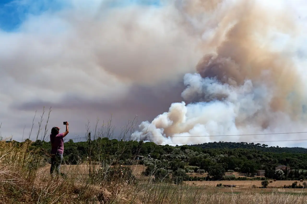 Alto riesgo de incendios forestales a Catalunya. Una persona hace una foto al humo del incendio, en La Bisbal d'Empordà, Girona, Catalunya / Foto: Glòria Sánchez-EP