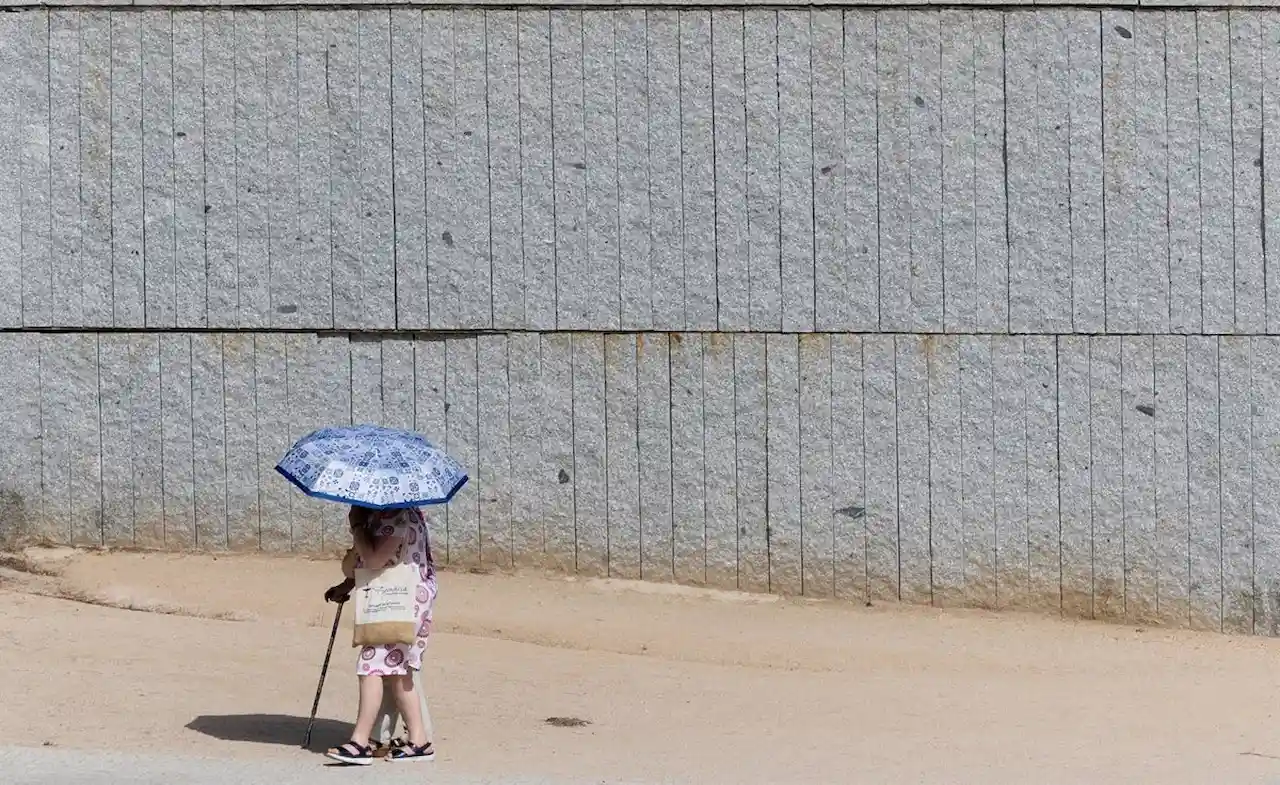 Dos personas se resguardan bajo un paraguas del calor / Foto: EP