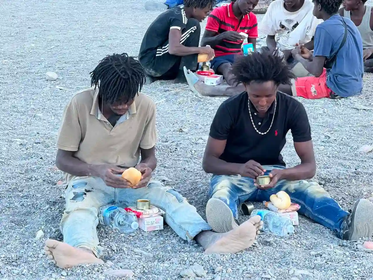 Dos migrantes reciben comida en Ceuta / Foto: EP
