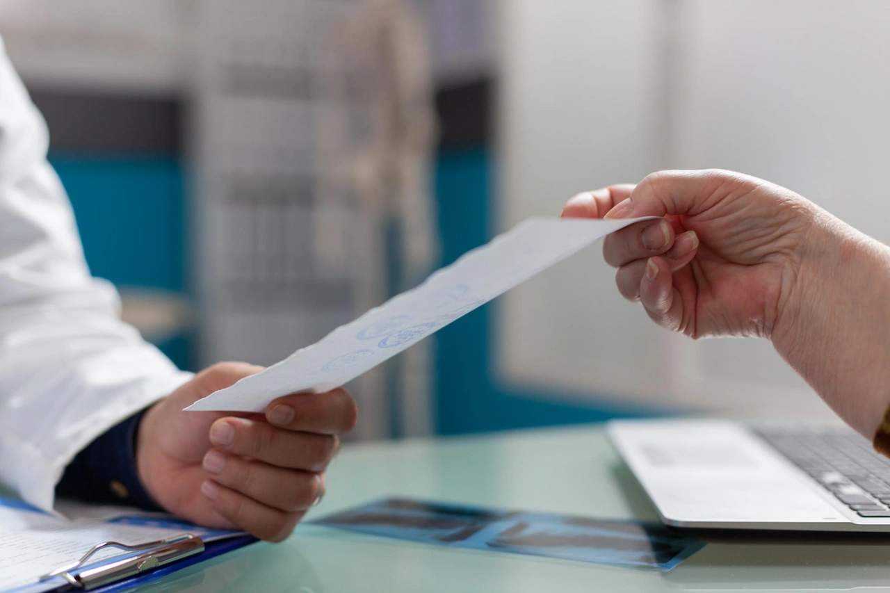 Un médico entrega una receta a un paciente en la consulta / Foto: FP