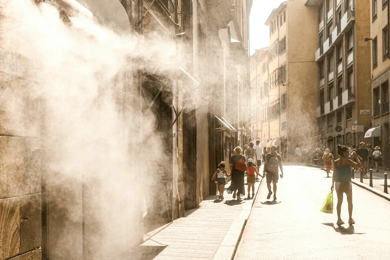 Viandantes bajo nebulizadores de agua en una calle de Florencia (Italia) durante una ola de calor, un fenómeno que las emisiones posteriores al Acuerdo de París han intensificado en Europa / Foto: UP