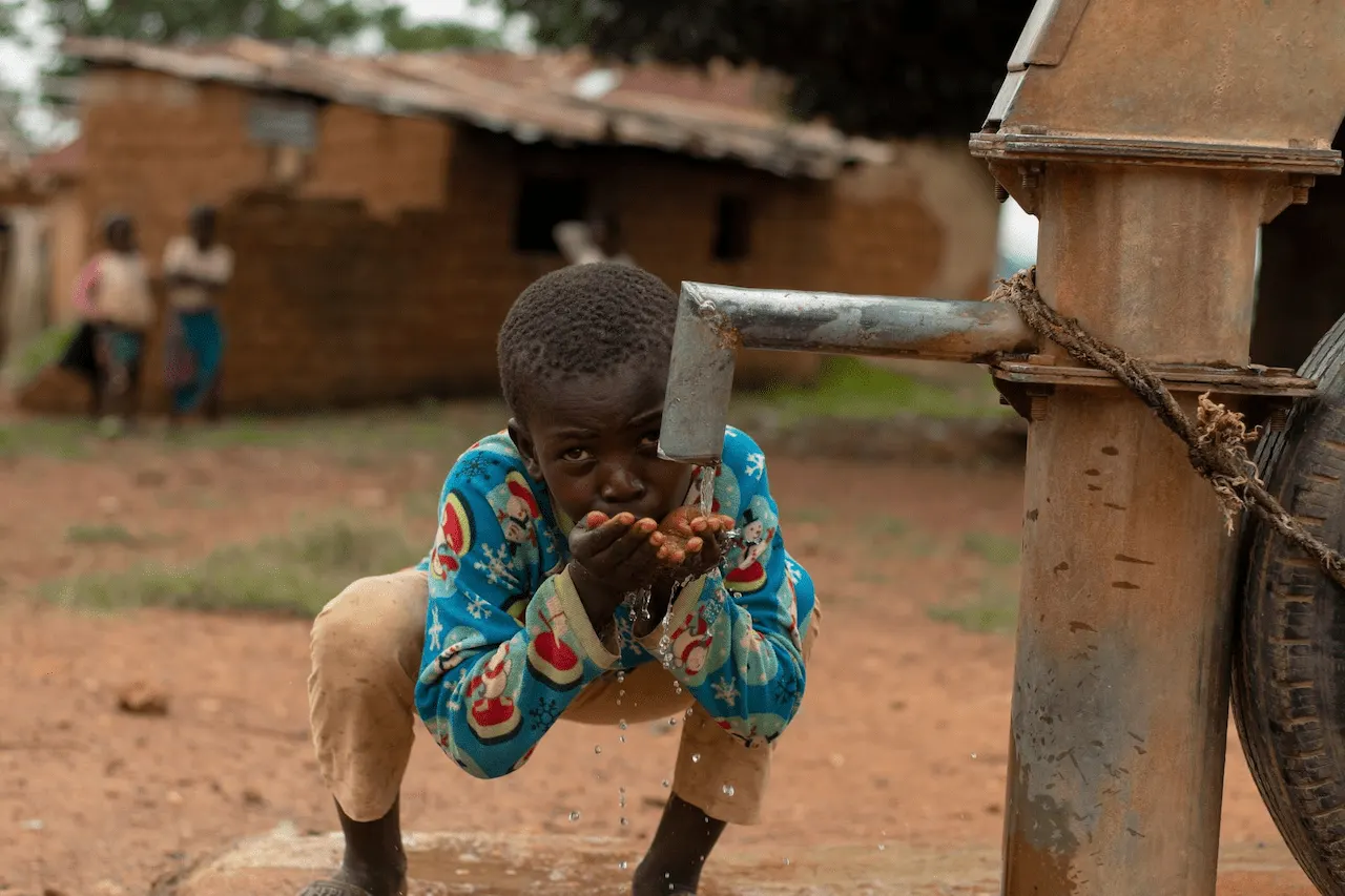 Un niño bebe agua de una bomba manual en una aldea de Kaduna, en Nigeria, el país con más muertes adicionales por calor previstas durante este El Niño / Foto: PX