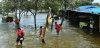 Personas caminan por una costa inundada en el norte de Yakarta, en Indonesia, una de las zonas amenazadas por la subida del nivel del mar / Foto: UP