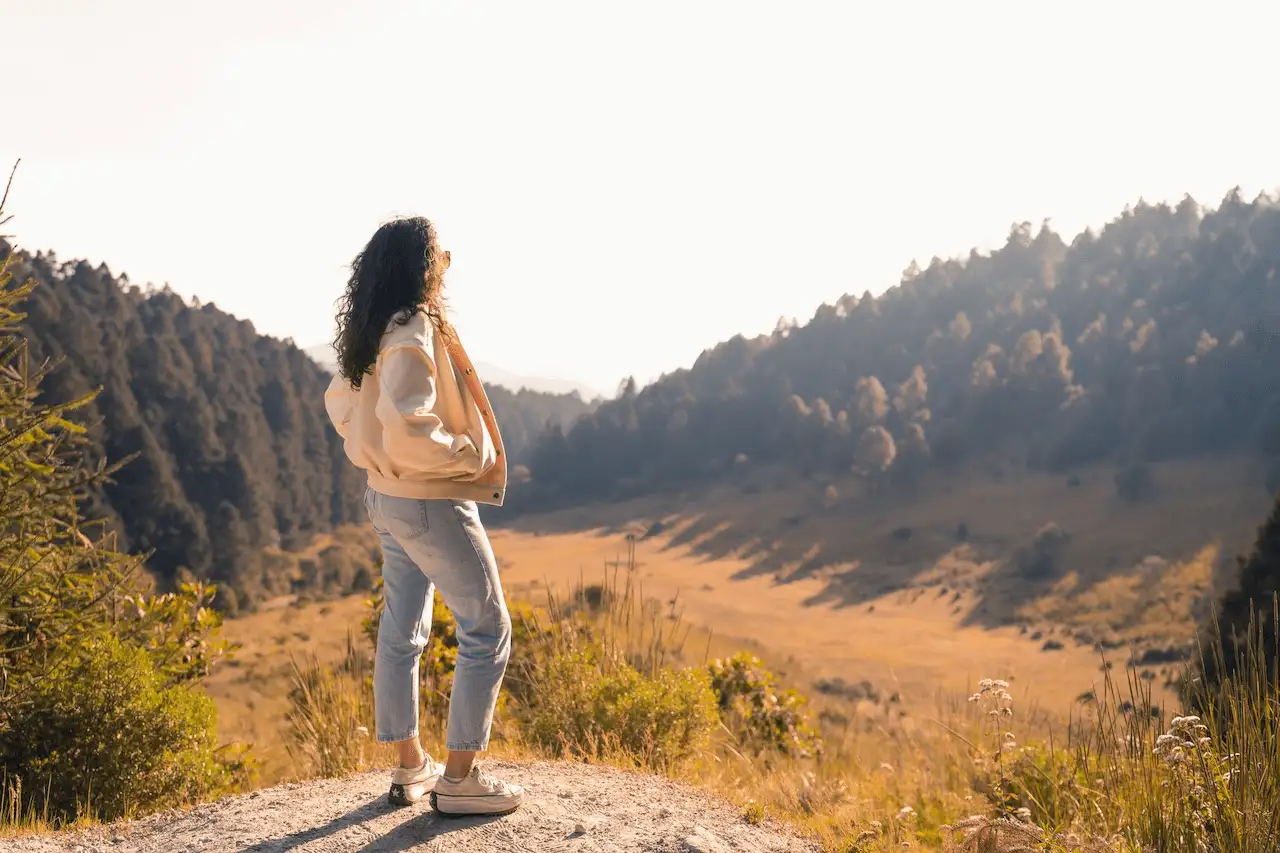 Una mujer contempla un valle rodeado de bosque. El Día Mundial de la Salud Mental 2026 reclama escuchar las experiencias vividas / Foto: PX