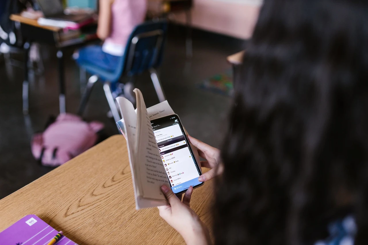 Un estudiante en clase combina la lectura con el uso del móvil, en una imagen de archivo sobre atención y diagnóstico del TDAH / Foto: PX
