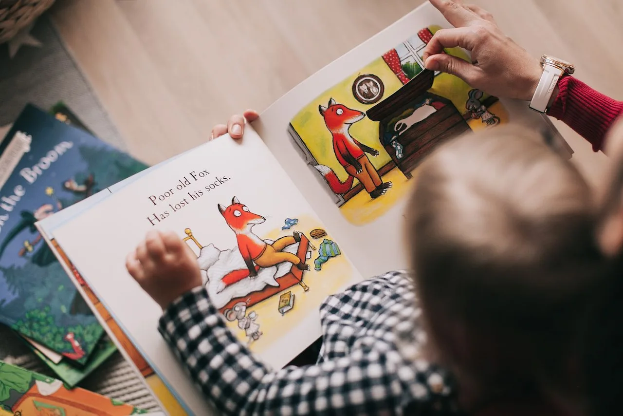 Un adulto y un niño leen juntos un libro ilustrado / Foto: PX Un adulto y un niño leen juntos un libro ilustrado / Foto: PX