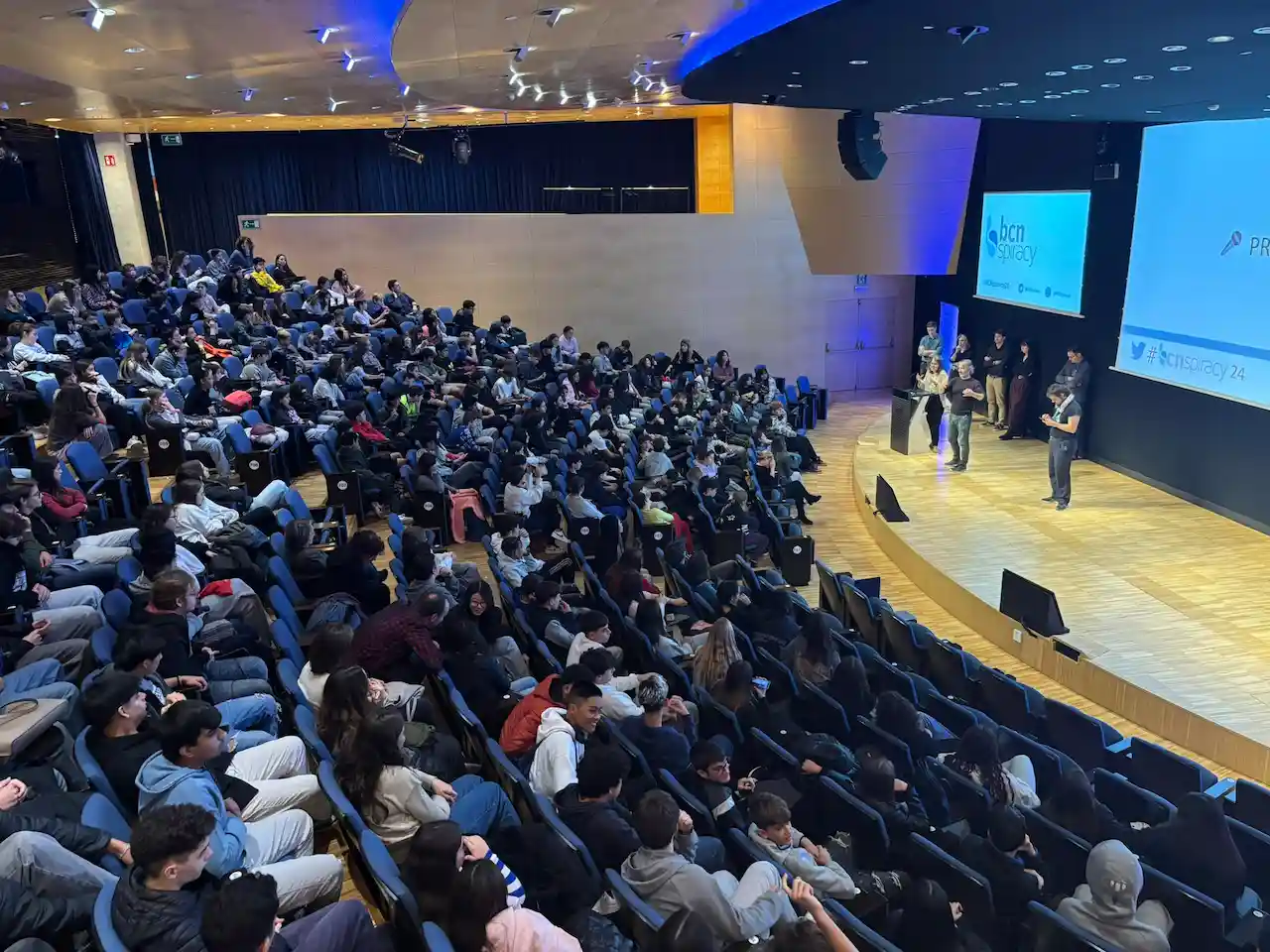 Público en un auditorio con el logotipo de BCNspiracy en pantalla, en la edición de 2024 / Foto:  BCNspiracy
