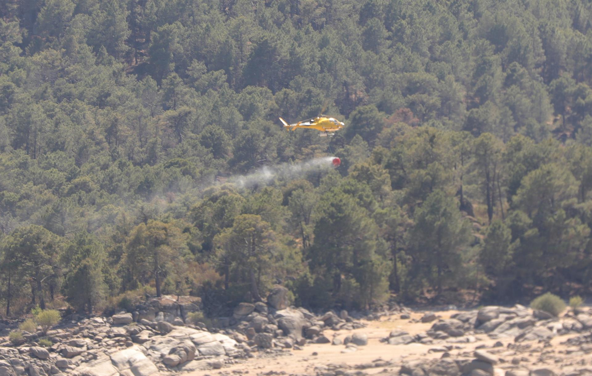 Un helicóptero recoge agua del pantano de Burguillos (Ávila) para extinguir un fuego / Foto: Jesús Hellín - EP