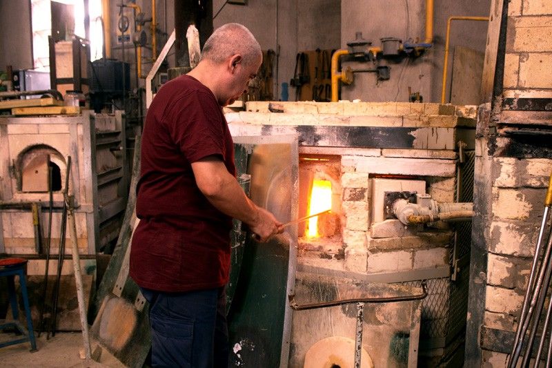 Un artesano retira vidrio fundido del horno con la 'caña', un tubo cilíndrico de acero hueco / Foto: CF