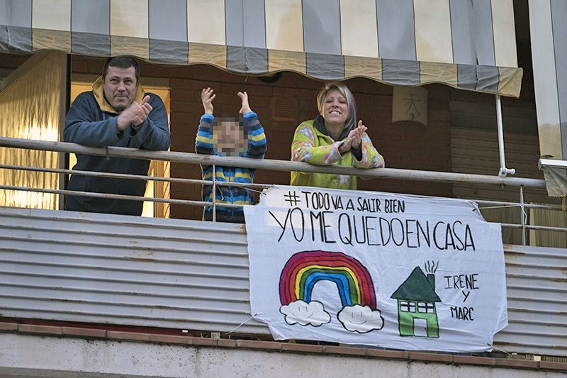 Vecinos de Polinyà (Barcelona) aplaudiendo para agradecer su labor al personal sanitario desde su balcón durante el confinamiento / Foto: Josep Cano