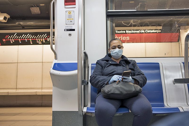 Una pasajera con máscara y guantes en un vagón semivacío del Metro de Barcelona / Foto: Josep Cano