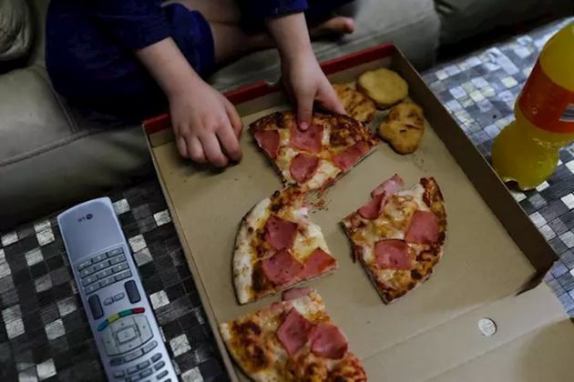 Un niño comiendo el menú subvencionado por la Comunidad de Madrid frente al televisor / Foto: EP