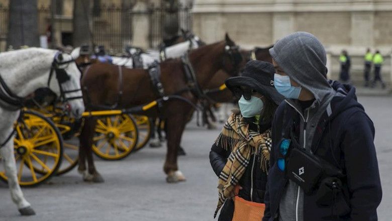 Turistas protegidos con máscaras junto a la catedral de Sevilla / Foto: María José López   EP