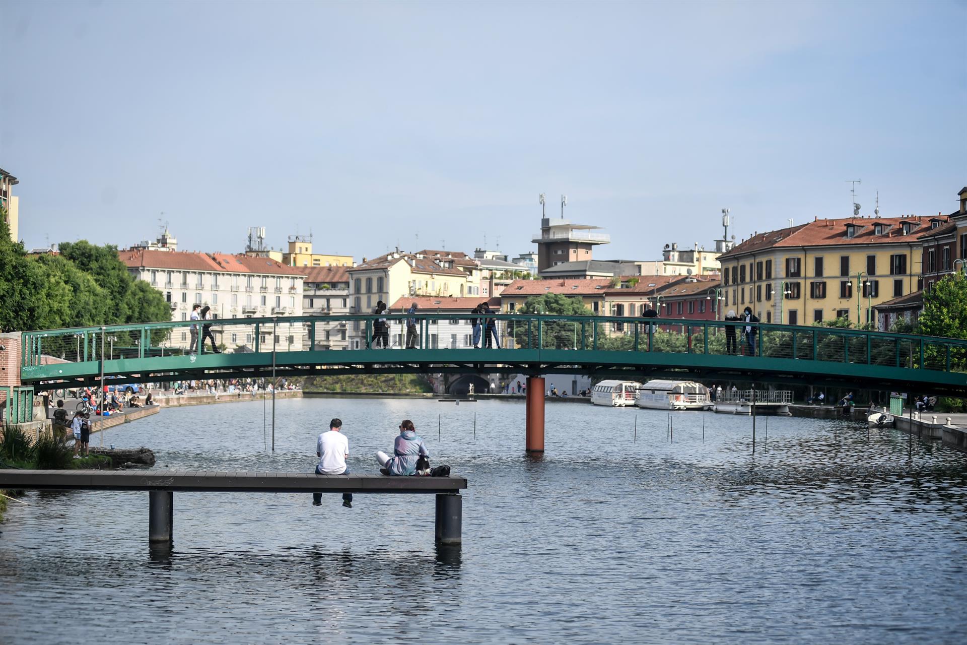 Dos personas sentadas junto a un puente en Milán, Italia / Foto: EP