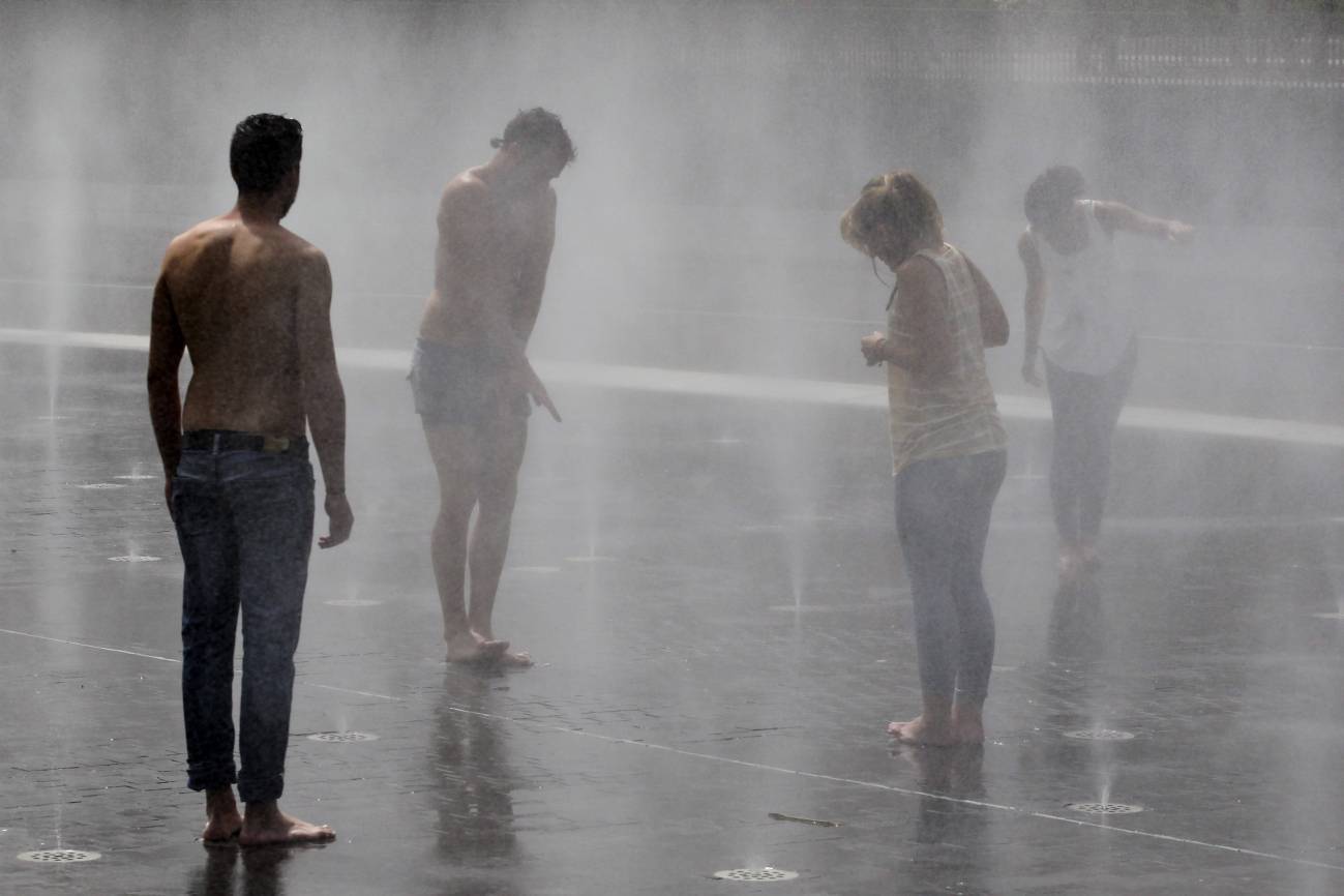 Varias personas se refrescan en una fuente de Madrid Río debido a las altas temperaturas del verano de 2015 /Foto: SINC
