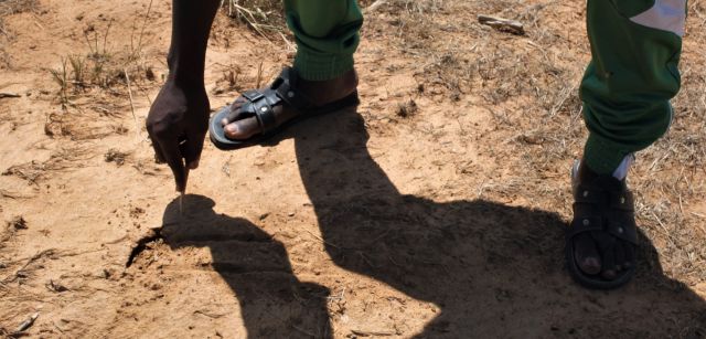 Elhadji Goudiaby, sargento encargado principal del proyecto en Mbar Toubab, Senegal, muestra como de árido es el terreno agrietándolo con ayuda de una pequeña vara de madera / Foto: AGP