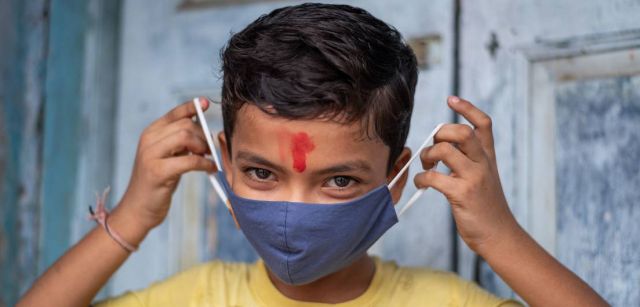 Un niño de 11 años en India muestra cómo ponerse correctamente una máscara para protegerse del COVID-19 / SINC