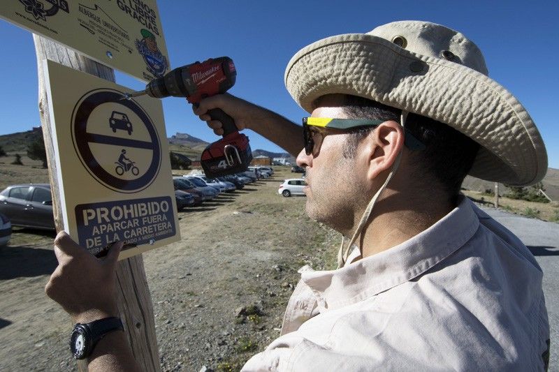 Un integrante del 'batallón' coloca un letrero prohibiendo el paso de vehículos en una zona protegida / Foto: Batallón Basurista