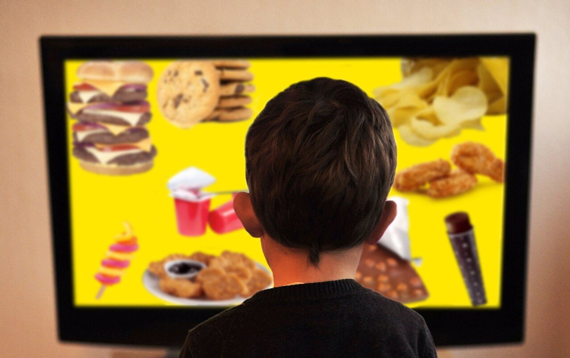 Niño frente al televisor con imágenes de comida nada saludable. Procesamiento sensorial y la obesidad infantil / Foto: EP