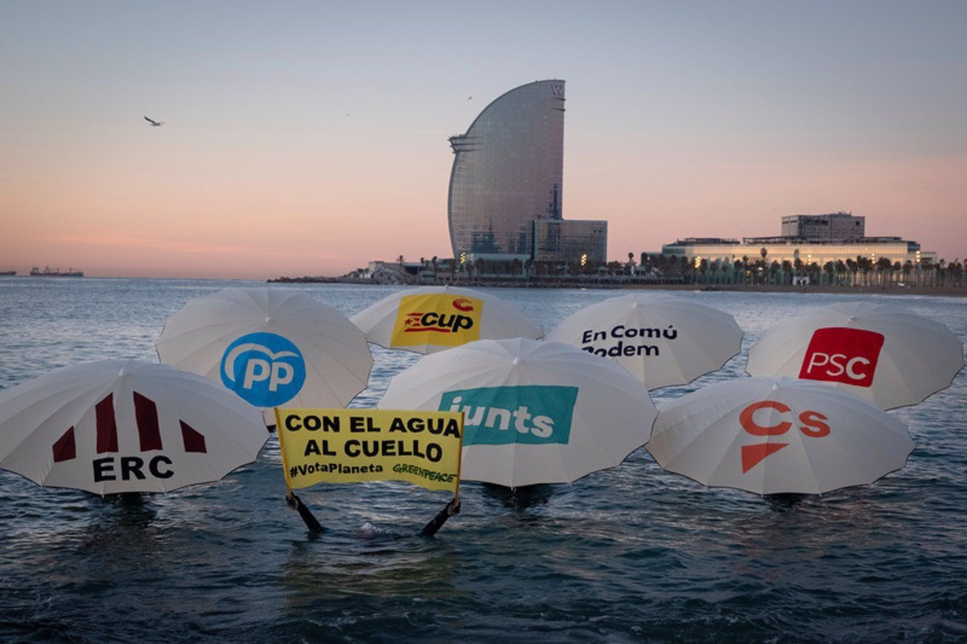 Acción de Greenpeace en una playa de Barcelona con motivo de las elecciones del 14F en Catalunya con una cartel en el que se puede leer: "Con el agua al cuello. #VotaPlaneta"/ Foto: EP