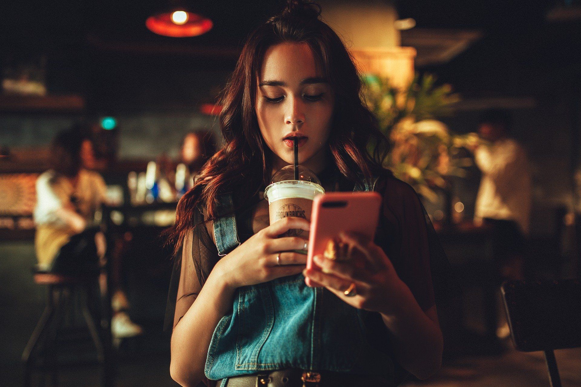 Una mujer joven toma una bebida en el interior de un bar. Coronavirus / Foto:  Kirill Averianov - Pixabay