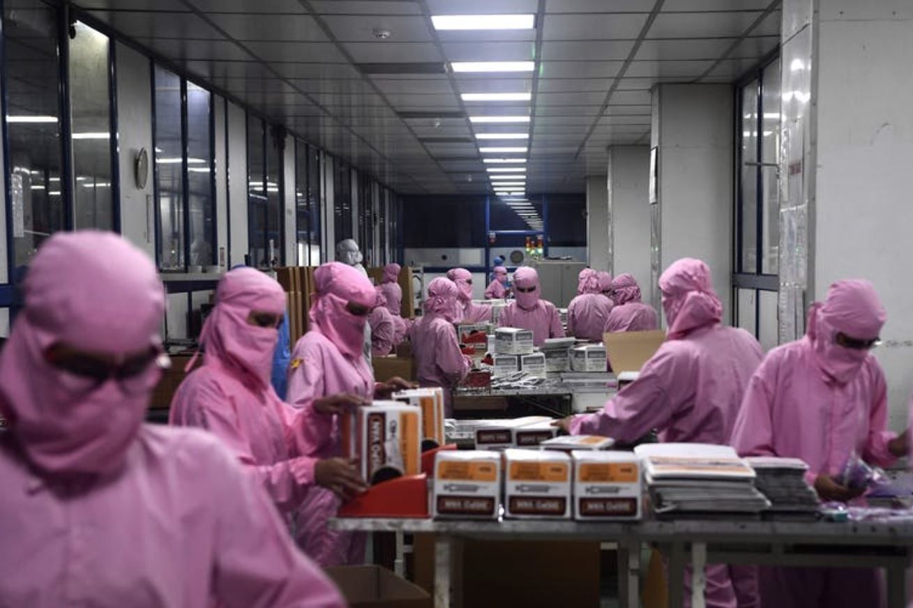 Trabajadoras empaquetan en una empresa de la India de producción de jeringuillas para las vacunas para la covid-19 / Foto: The Conversation